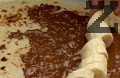 Намазваме ги с течен шоколад, редим кръгчета банан, слагаме топки сладолед.