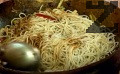Прибавяме охладените спагети, наливаме соев сос и 1 ч.ч. пилешки бульон, разбъркваме добре.