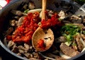 Нарязваме лука и гъбите на полумесеци, а чушката - на кубчета. Наситняваме зелената част на лука, добавяме нарязаните зеленчуци. Пържим съставките до готовност, като разбъркваме периодично. Поливаме с вино, задушаваме.