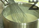 En otro recipiente, mezcla las yemas, la harina y la leche restante hasta obtener una mezcla homogénea. Vierte poco a poco, en un hilo fino y sin dejar de remover, la leche caliente con el azúcar. Devuelve la mezcla a la cacerola y cocina, removiendo constantemente, hasta que espese. Al final, añade