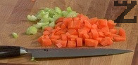 Изваждаме месото, прибавяме в бульона нарязаните на кубчета моркови и втория стрък целина.