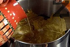 Покриваме с няколко лозови листа, наливаме вода, така че да покрием сармите. Посоляваме отново и затискаме с чиния. Варим под капак на слаб огън около 40 мин.