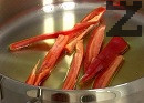 Нарязваме чушката на ивички. 2-3 от тях отделяме и нарязваме на кубчета, а останалите запържваме в леко загрят зехтин за около минута.