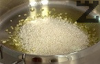 В същата мазнина запържваме за кратко наситнения чесън и ориза, който сме измили предварително.