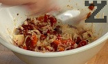 Приготвяме топинга. Нарязваме на дребно доматите и чушките. Поставяме ги в купа, поръсваме със сухия чесън, поливаме със зехтин. Настъргваме сиренето, размесваме добре.