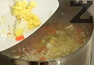 Нарязваме лука, моркова и картофите на кубчета. Прехвърляме ги в рибния бульон заедно с почистената риба, посоляваме.