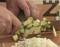 Нарязваме лука на ситно, а тиквичките - на малки кубчета.