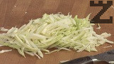 Нарязваме зелето и го притриваме с 1 щипка сол.