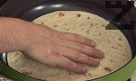 С малко олио намасляваме тигана и слагаме месото да се пържи.За кратко затопляме тортилята в сух тиган.