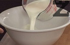 В една купа слагаме прясното мляко, яйцата, кимиона, кората на 1 лимон и разбъркваме.