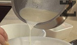 Наливаме на тънка струйка загрялото прясно мляко. Връщаме на котлона, варим, докато крема се сгъсти. В самия край добавяме шоколадовите пелети, размесваме добре.
