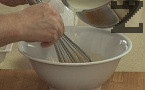 Горещата сметана изливаме на тънка струйка към жълтъците, като разбъркваме непрекъснато.