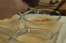 Изчакваме десерта да изстине за около 5-6 часа, след което по повърхността на всяка купичка равномерно разпределяме захар. Карамелиризаме с помощта на готварска горелка.