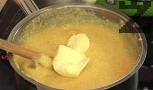 Прибавяме крема сиренето и кравето масло. Разбъркваме енергично, докато всичко се разтопи и сместа стане хомогенна.