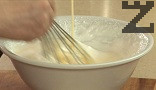 Разбъркваме добре сместа от двете купи с помощта на шпатула или готварска тел, прехвърляме сместа в кръгла тавичка с диаметър 20-22 см, на дъното на която сме поставили хартия за печене.