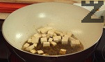 В сгорещената мазнина пържим за 10-20 сек. джинджифила, заедно с чесъна. Поливаме с половината от соса, добавяме сиренето тофу, морковите и чушките.