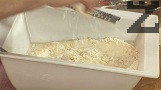 Постепенно наливаме 280-300 мл хладка вода /до 35 градуса/. Поливаме с олио, добавяме настърганото на едро ренде сирене и нарязания на малки парченца бекон, но без сланината.