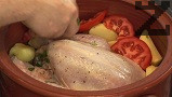 Обелваме картофите, режем ги на едри парчета, подреждаме ги около пилето. Режем доматите на по-дебели филийки /полумесеци/, редим върху картофите.