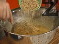 В купа се сипват олио, кафявата и бялата захар и хубаво се разбиват, докато олиото поеме захарта. След това се прибавят яйцата и ванилията. Сместа се разбърква, докато съставките се смесят. После се прибавят орехите и сухото мляко.Сместа се подправя с канела, сол, сода и бакпулвер.