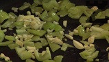 Приготвяме доматения сос. Пържим за 1 мин. кубчетата зелена чушка. Прехвърляме и нарязаните на по-едро скилидки чесън.