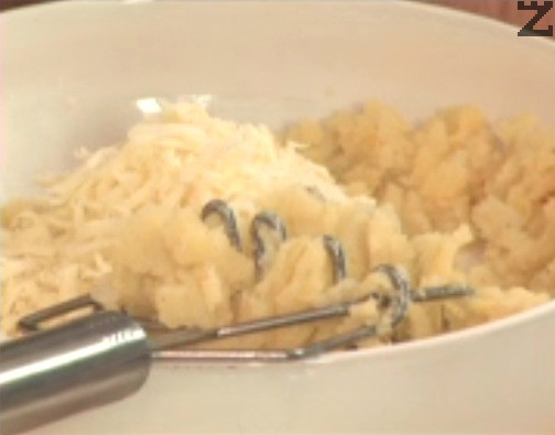 Incorporamos el queso rallado grueso y el huevo. Mezclamos y machacamos todo muy bien. Al final, añadimos un poco de leche. 