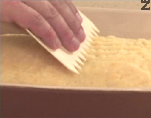Marcamos suavemente la superficie con un tenedor o un peine de repostería y espolvoreamos con pan rallado. 
