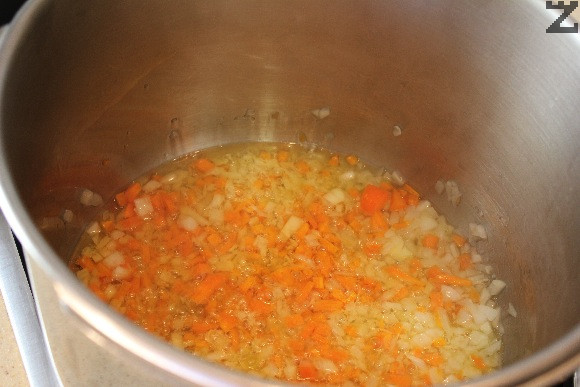 В тенджера под налягане се налива олиото и се загрява. Слагат се лука и моркова и запържват за 30 сек. 