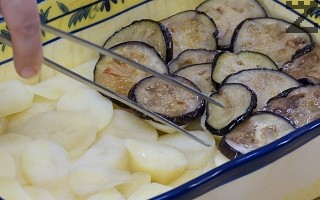 В тавата при наредените картофи се слагат патладжани и покриват с половината кайма. 
