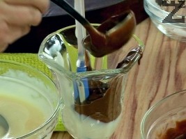 От двете купички се гребва с черпак по равно и едновременно се разпределя в чаши или купички така че да се получат два цвята крем като можем да си помогнем правейки преграда със шпатула. Покрива се с фолио и оставя да изстине. Разбива се сметаната със захарта шприцова се в чашите за декорация и м